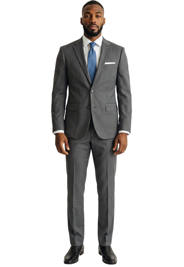 A man wearing a Cosiani grey slim fit Italian wool suit with a white shirt, blue tie, and pocket square.